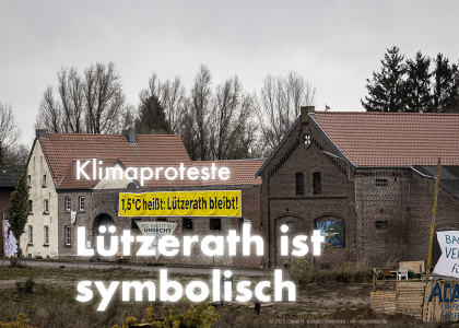 Eine Häuserzeile in Lützerath. Daran hängt ein Plakat das knallgelb hervorsticht. Es sagt: "1,5 °C heißt: Lützerath bleibt". Auf dem Bild steht: "Klimaproteste: Lützerath ist symbolisch". | © Claus R. Kullak | Wikipedia | crk-respublica.de